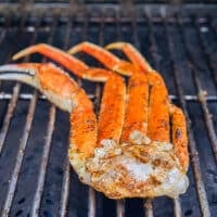 Crab legs grilled and charred on a grill, ready to enjoy