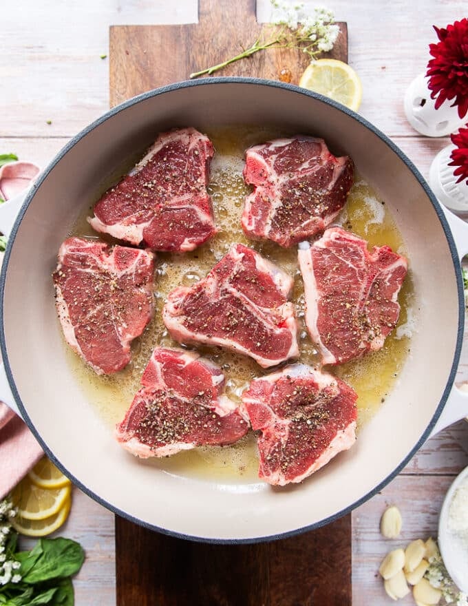 Lamb chops added to a skillet with butter and oil 