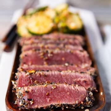 close up of a plate of seared ahi tuna stacked in slices