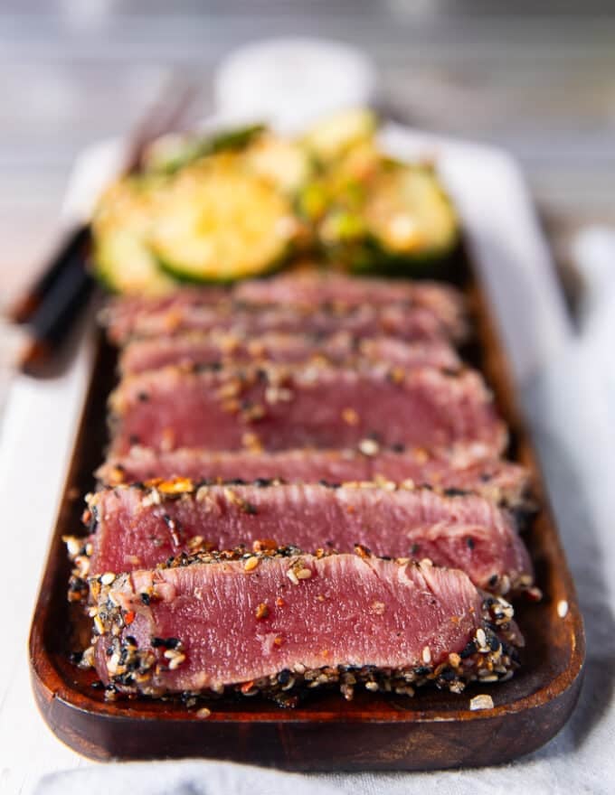 close up of a plate of seared ahi tuna stacked in slices 