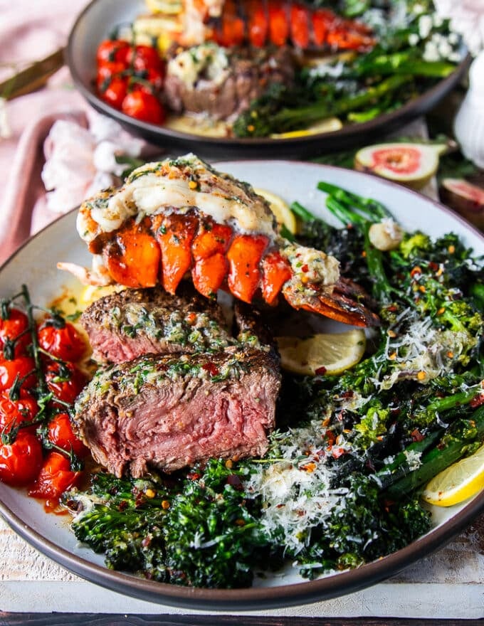 Fillet mignon cut in half on a surf and turf plate showing the medium rare doneness inside