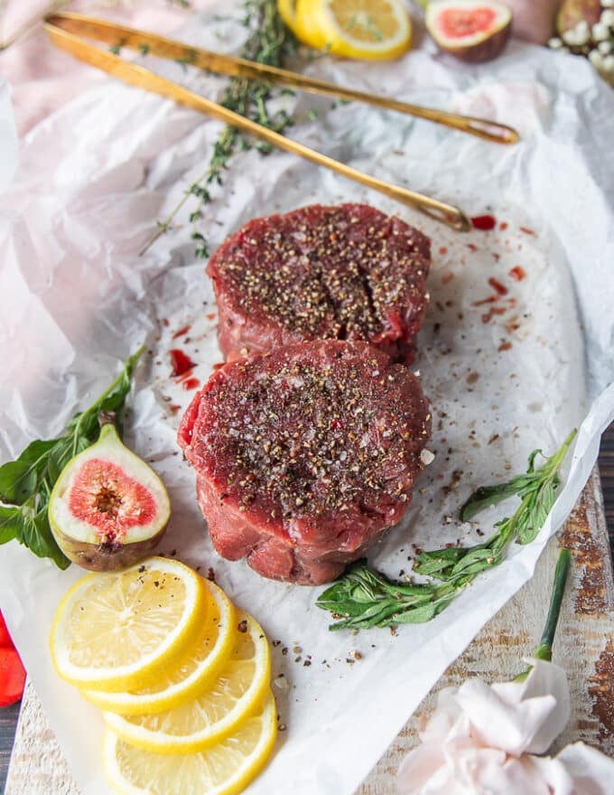 two pieces of fillet mignon seasoned on both sides with generous amounts of salt and pepper