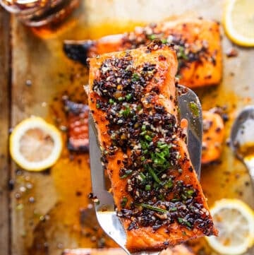 A spatula holding a piece of sweet chili salmon close up, cooked and ready