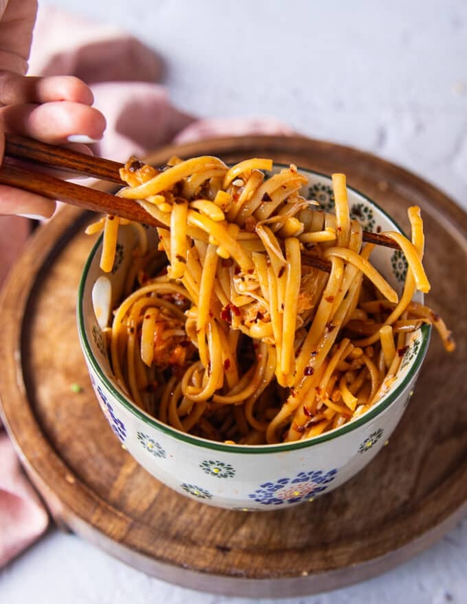two chopsticks holding up crab pasta showing the chili pasta and the crabs