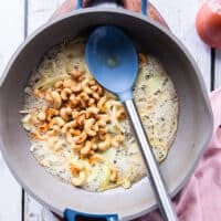 Cashews are added to the rice pan with onion and butter when the onions have softened