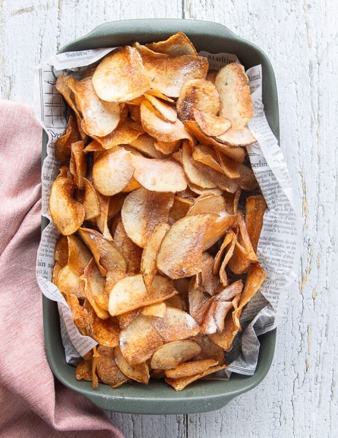 A large plate of potato chips seasoned and ready to serve. 