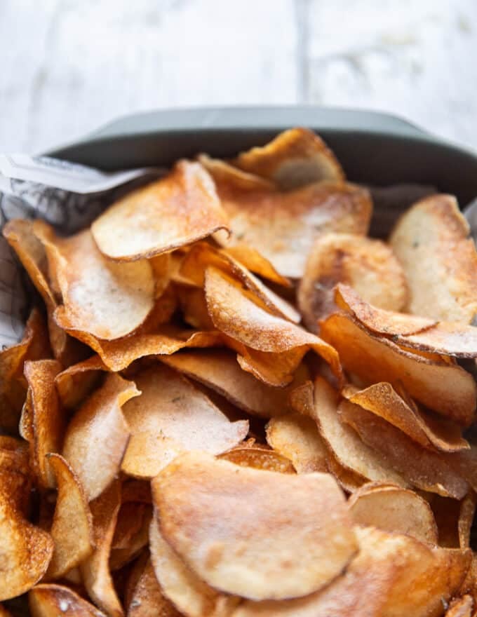 close up of crispy fried potato chips showing the crispiness and seasoning and golden color 
