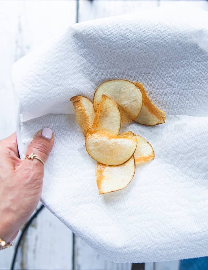 The potato chips removed from the oil and placed on paper towels to drain