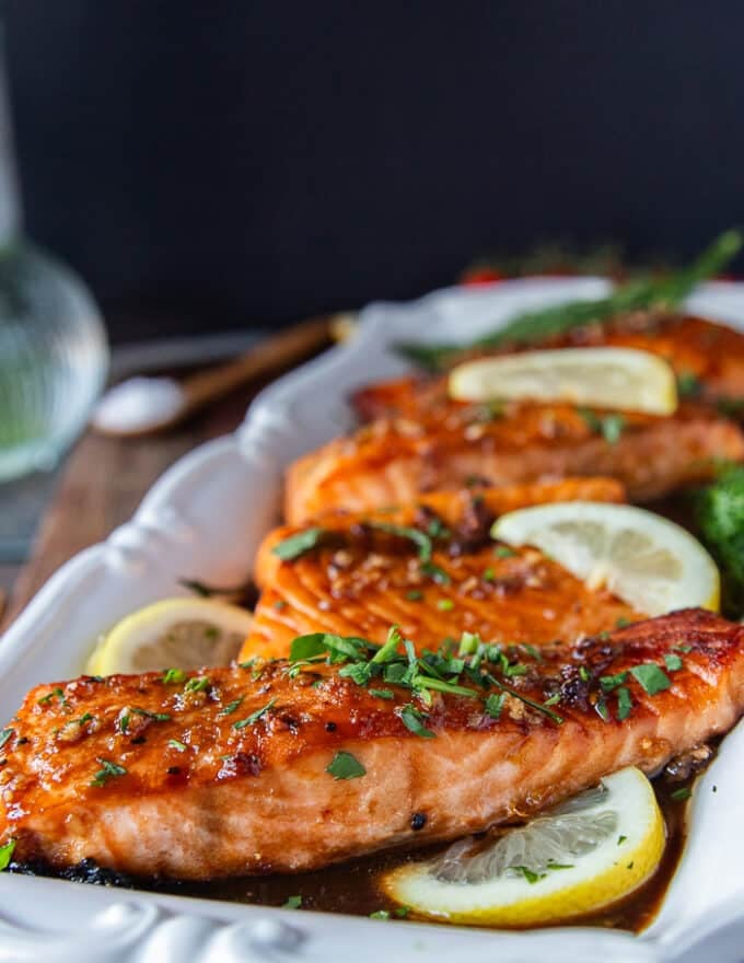 A plate of maple glazed salmon with the maple glaze golden and toasty over the salmon