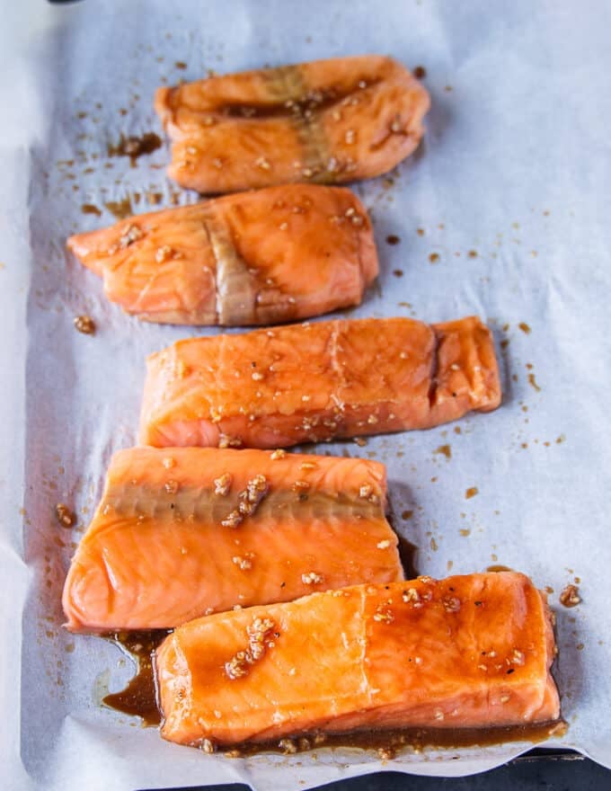 fully maple glazed salmon fillets on a baking sheet ready to go in to the oven 