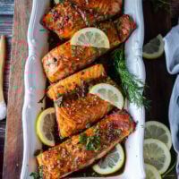 finished plate of maple glazed salmon fillets served with lemon slices