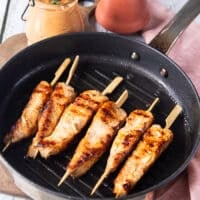 cooked and charred halibut flipped on the grill pan to continue grilling on the other side