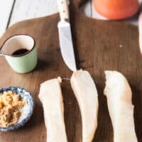 A piece of halibut fish cut into three long strips to grill