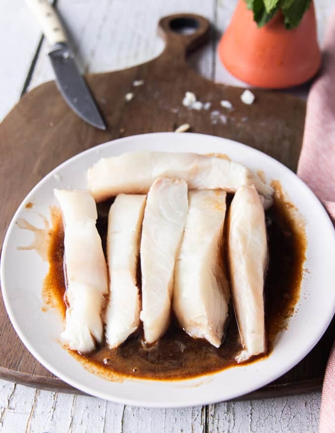 The halibut pieces added to the marinade plate and tossed 