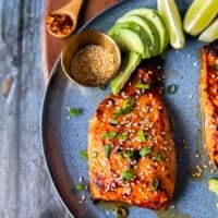close up of one miso salmon on a plate garnished with sesame seeds and green onions