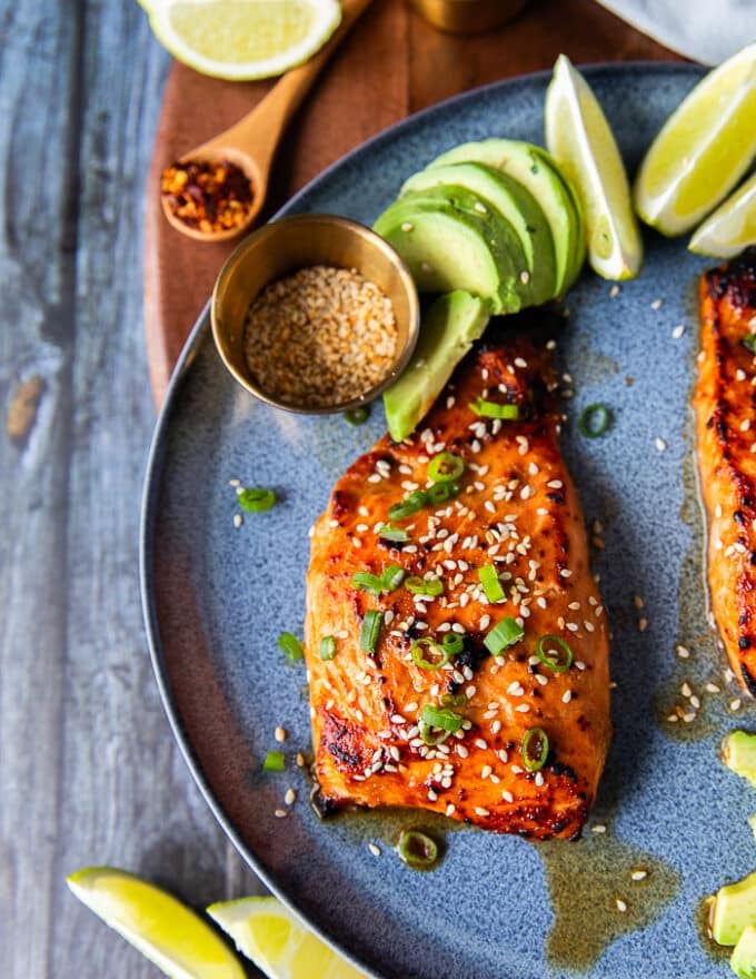 close up of one miso salmon on a plate garnished with sesame seeds and green onions