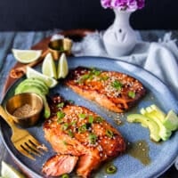 A plate with miso salmon and avocado and a fork breaking up the salmon showing how succulent it is
