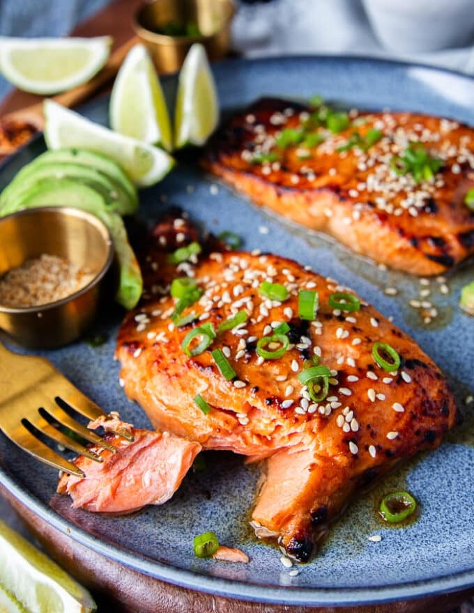close up of a fork flaking the miso salmon showing how succulent it is and the beautiful charred crust on top