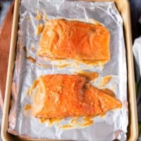 The salmon fillet drenched in miso marinade on both sides on a baking sheet