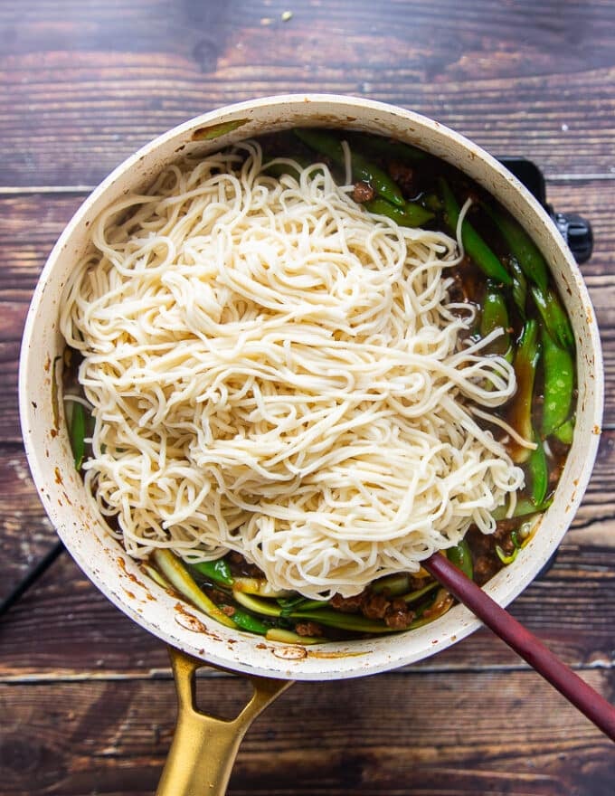 cooked noodles are added into the skillet with the Mongolian ground beef