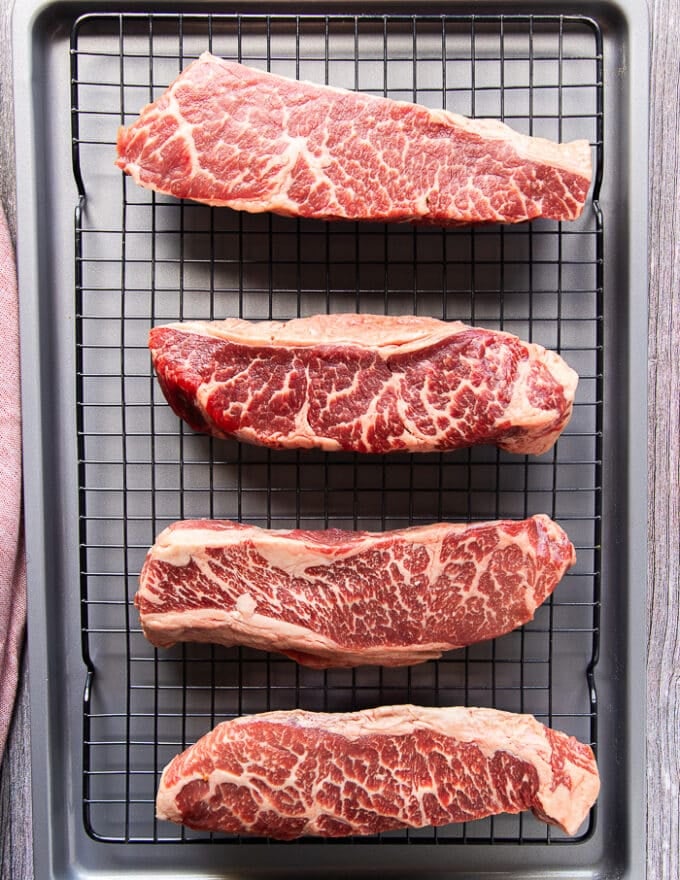 Ingredients for reverse sear steak including the steak, some salt and pepper and the butter for searing 