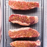The steak sprinkled with salt and pepper and placed on a wire rack over a baking sheet