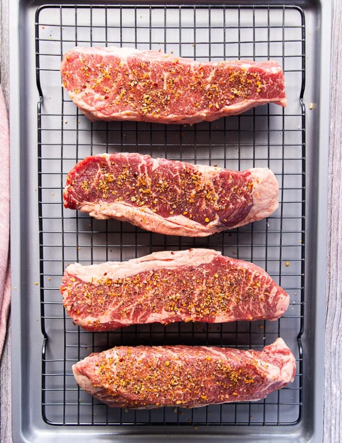 The steak sprinkled with salt and pepper and placed on a wire rack over a baking sheet