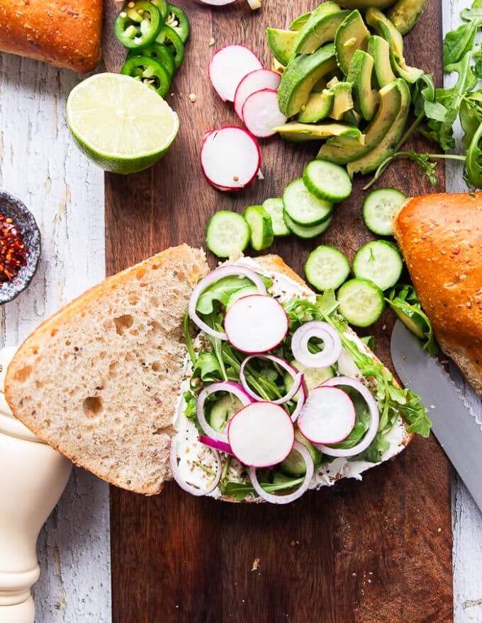 Some toppings starting to pile at the smoked salmon sandwich like arugula, onions, radishes 