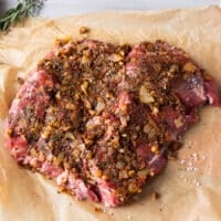 The onion mixture is pressed well into the lamb