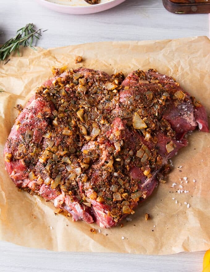 The onion mixture is pressed well into the lamb 