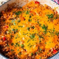 close up of a stuffed pepper casserole showing the melted cheese on top, the cooked rice, meat and peppers underneath
