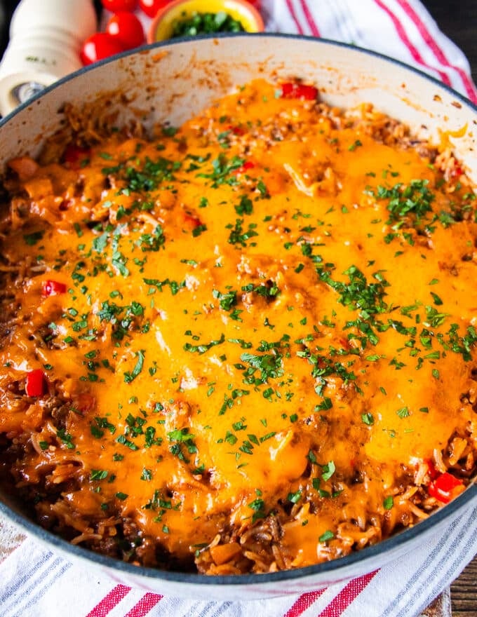 close up of a stuffed pepper casserole showing the melted cheese on top, the cooked rice, meat and peppers underneath
