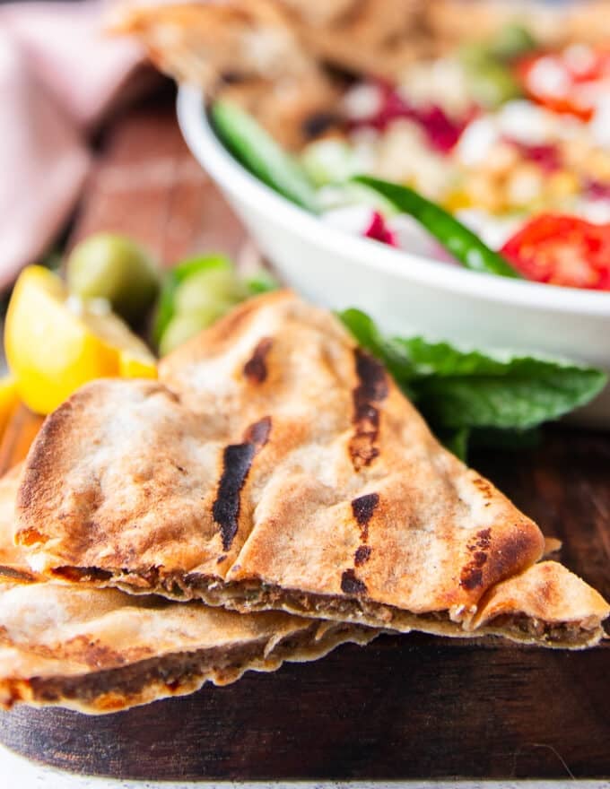 close up of a thin meat stuffed pita bread cooked and showing the meat