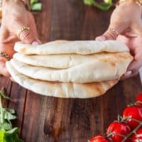 A hand holding a stack of thick pita stacks