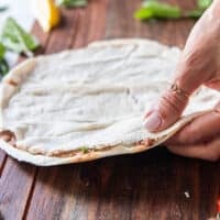 The top layer of the thin pita bread is now placed over the meat filling and pressed down