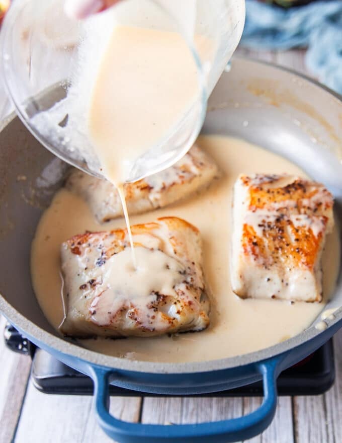 the cooked black cod is returned to the skillet and the creamy lemon beurre blanc sauce is poured right over it 