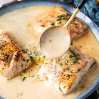 A spoon pouring some cream butter sauce over the black cod recipe to flavor it