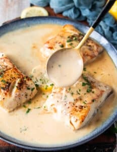 A spoon pouring some cream butter sauce over the black cod recipe to flavor it