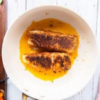 charred and seared cajun spiced halibut or chicken in a skillet