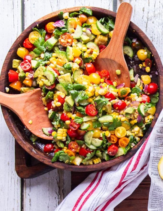 final bowl of corn and tomato salad with two wooden handles