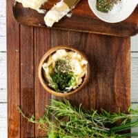 The herb butter is mixed together in a small bowl ready to slather over the corn on the cob