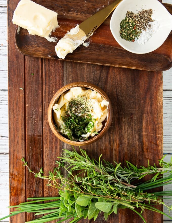 The herb butter is mixed together in a small bowl ready to slather over the corn on the cob