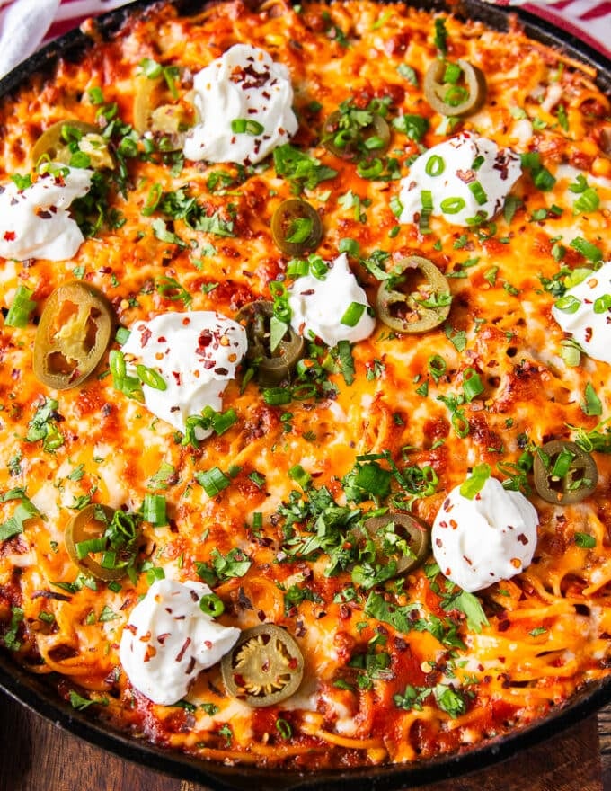 close up of a small piece of the taco spaghetti skillet showing the texture of the melted cheese, and toppings 