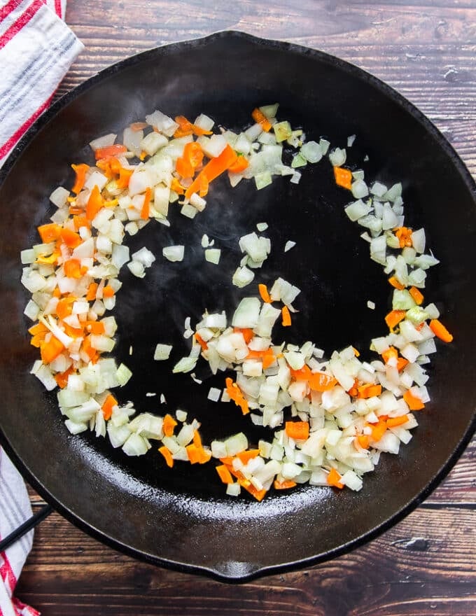a cast iron skillet with minced onions and peppers