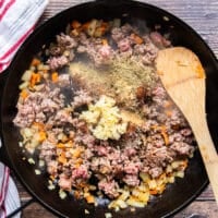 The ground beef, mined garlic and taco seasoning are added to the skillet to make the taco meat mixture