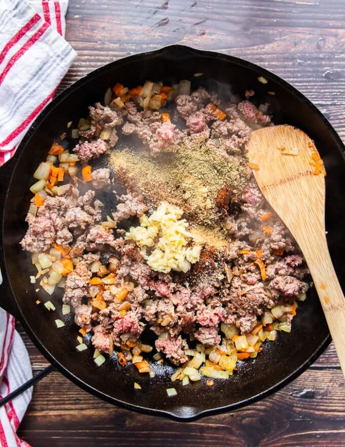 The ground beef, mined garlic and taco seasoning are added to the skillet to make the taco meat mixture 