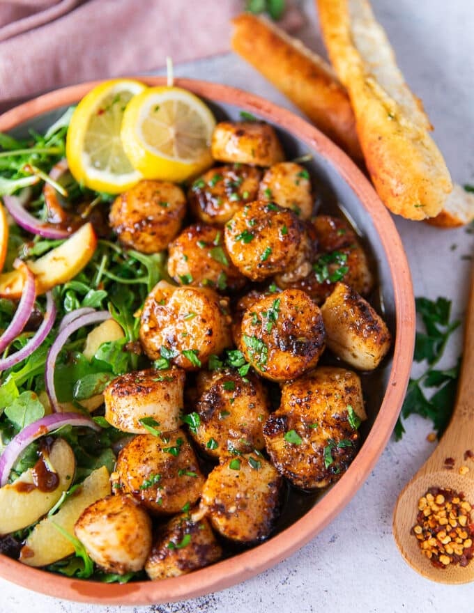 close up of broiled scallops showing the golden color and juicy scallops 