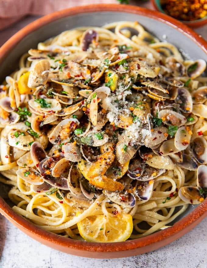 Cerca de la pasta de almeja en un plato que muestra la textura de la pasta, la salsa de almejas y las almejas cocidas 
