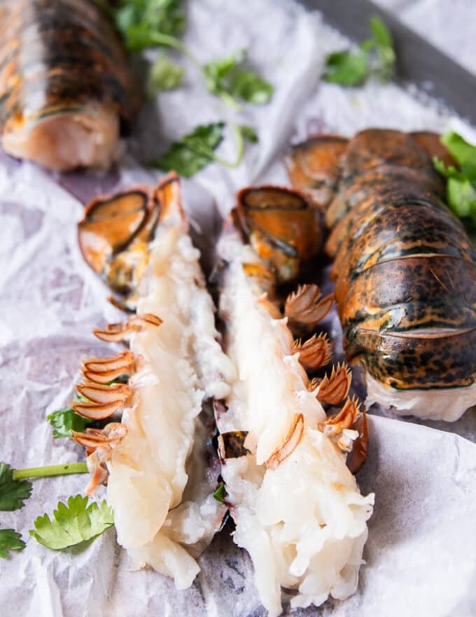 A lobster tail split in half with the meat inside ready to season 