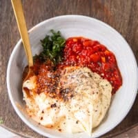 Ingredients to make harissa aioli all added into one bowl and a spoon on the side to mix them up